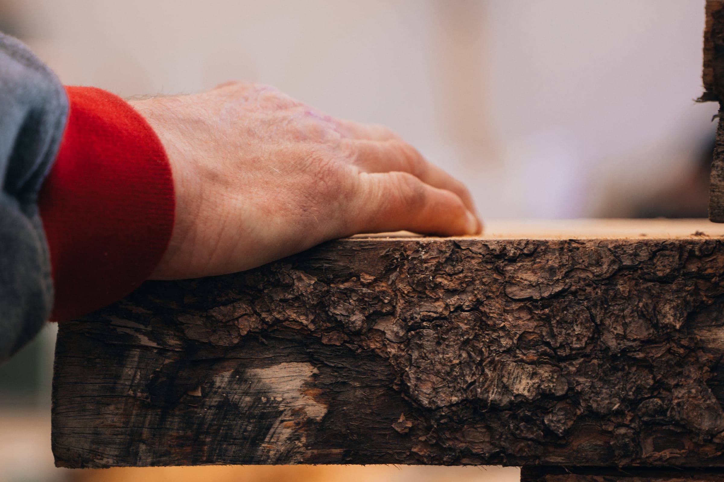 Hand auf einem frisch gelieferten Zirbenholz-Balken